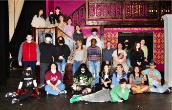 Members of the Goshen High School musical cast pose in front of their set for “The Addams Family.” Photo provided.