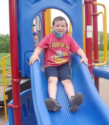 Five-year-old Devin Stamp enjoying the slide at the playground constructed for the Faith First preschool @St. Columba.