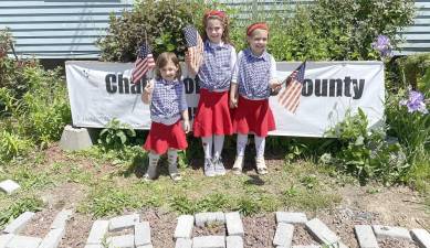 Raizel (5), Toby (4), and Chaiky Borenstein (8) hold American flags in front of the Chabad Jewish center in Goshen on Memorial Day, recognizing those who have fallen while fighting for freedom. (www.chabadoc.com).