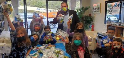 Rabbi Pesach Burston distributes some Chanukah goodie packages to students at Chabad Hebrew School. They contained a dreidel popper, a dreidel, chocolate coins and a Chanukah treat. There will be lots of swag and goodies that will be distributed at the Chabad community Chanukah events. Provided photos.