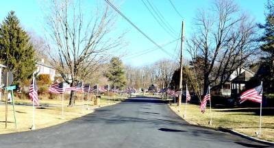 Members of Warwick Valley Rotary and the Warwick Knights of Columbus planted 140 of Rotary’s Flags for Heroes outside the homes in the Prial family’s neighborhood. Photo by Roger Gavan