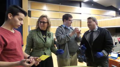 Students show school board members how to take fingerprints (fromm left): student Jimmy Cendano-Franco with school board members Sandy Naglar, and student Donald Mee with school board member Frank Sambets (Photo by Frances Ruth Harris)