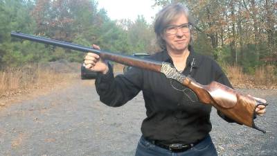 Gail holding a finished rifle: lock, stock, and barrel