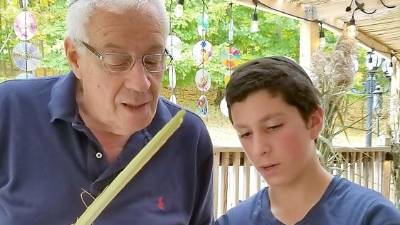 Duvy Burston of Monroe assists Al Muhlrad of Goshen with the shaking the Four Kinds, a mitzvah on the holiday of Sukkot.