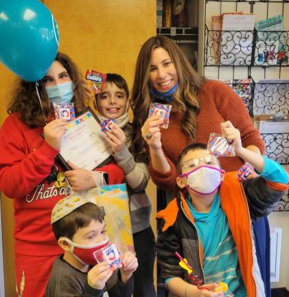 Chana Burston celebrated Chanukah with Chabad Hebrew School students Fiana and Landon Goldenberg of Warwick and Hudson and Ethan Mendelovits of Central Valley, gifting students with dreidel fidget toys and other Chanukah goodies.
