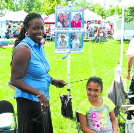 Haidresser Celia Harewood of Chester gives Victoria Lopez, 9, of Monroe a fancy &#x2018;do at the Beaded Braids &amp; Beyond booth.