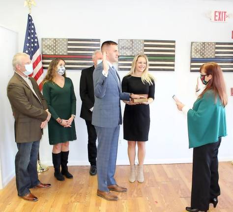 Assemblyman Colin J. Schmitt is administered the oath of office at 11 a.m. last Wednesday, Jan. 6, by Orange County Clerk Annie Rabbitt; the assemblyman’s wife, Nikki Schmitt, holds the bible with his family in the background. The photo was provided by the assemblyman’s office.