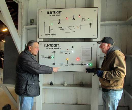 Museum board chairman Paul Campanella (left) and trustee and museum engineer Bill Lemanski inspect the electric panels designed and built by the Museum Village, financed by Orange and Rockland Utility Company.