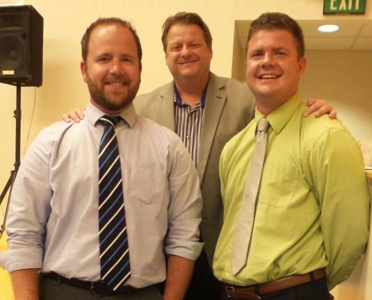 School board President Frank Sambets and math teacher Shawn Cunningham welcome Shawn’s brother, Ryan Cunningham, who is joining the staff this fall as a health and physical education teacher. (Photo by Frances Ruth Harris)
