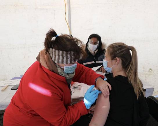 Mary Pat Bailey, a RN with Horizon Family Medical Group, administers a vaccine to Dental Assistant Kristy Castro of Pine Bush.