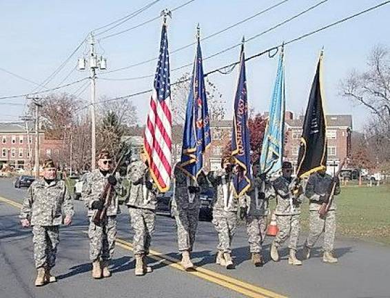 The Color Guard for Goshen Veterans of Foreign Wars Post 1708 and Goshen American Legion Post 377 led by Commander Ray Quattrini (left) march up North Church Street in the Village of Goshen.
