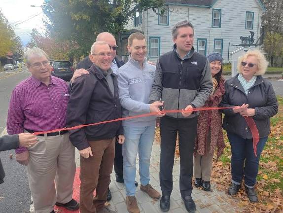 Sen. James Skoufis and Chester Town Supervisor Brandon Holdridge prepare to cut the ceremonial ribbon for the Sugar Loaf sidewalk project on Oct. 31, 2025.