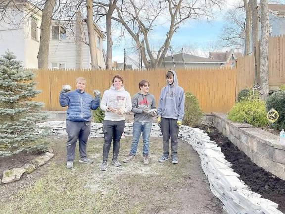 Alex Canale (left) led his fellow scouts in constructing several stone walls and flower beds, including (left to right) Dan Hartley, Eric Bunzey, and Jason Barnes.