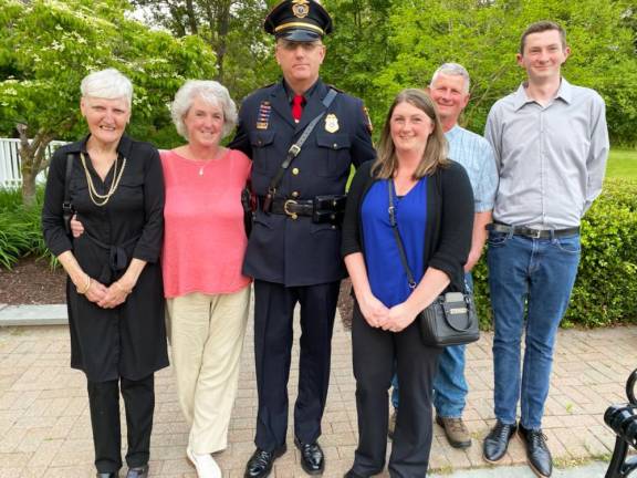 Retiring Village of Goshen Police Sgt. Christopher Smoulcey (center) with his family after he was honored during the May 22, 2023 Goshen Village Board meeting.