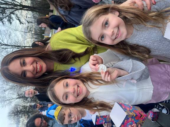 Chana Burston congratulates children who found the winning “golden gelt” coin at the annual “Chanukah Gelt Drop” at Chabad of Orange County.