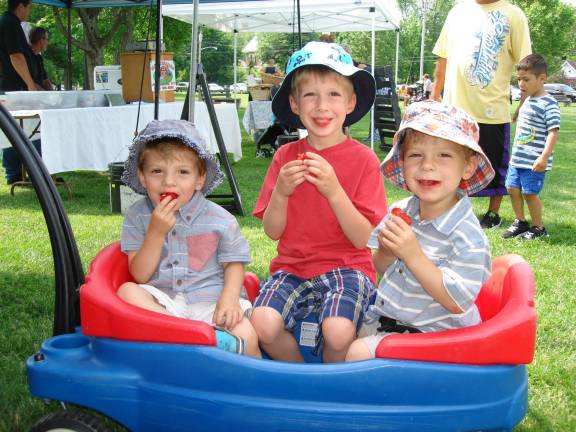The Orr brothers from Campbell Hall love coming to the farmers market with their mom, Amber, who said they come every week. Pictured (from left): Alex, 3, Camden, 5, and Wyatt, 3, nosh on fresh strawberries. Twins Alex and Wyatt were proud to announce that Friday was their birthday, while Camden noted that he&#x2019;s starting kindergarten in Goshen in September. (Photo by Geri Corey)