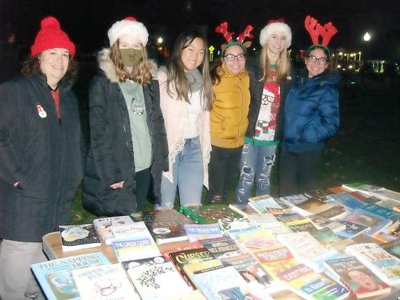 Junior Friends of Goshen Public Library stand with their advisor, Elizabeth Tarvin, on the far left. They’re thrilled to give children who came to the table a choice of two free books of their own to bring home.