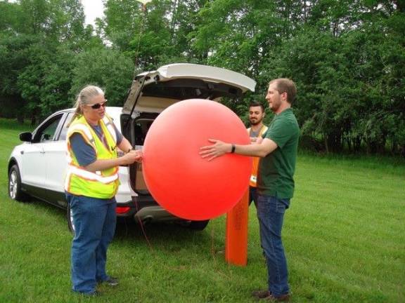 Dina Peoples, Harrison Colander, and Chris Callinan, with Tectonic Surveying &amp; Engineering prepare a balloon for the Fiddler's Green visual assessment test. (Photo by Geri Corey)