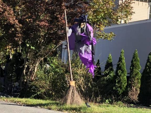 A witch flies in front of a house on Macopin Road in West Milford. (Photo by Kathy Shwiff)