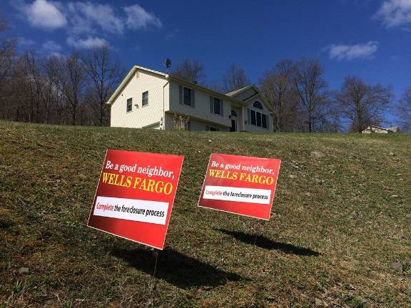 Signs throughout the Hudson Valley aim to shame the banks keeping properties in foreclosure "limbo" for years.