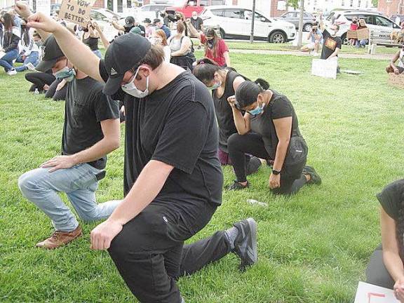 Participants in the protest kneeling in solidarity during a moment of silence honoring so many who lost their lives to brutality. Photo by Geri Corey.