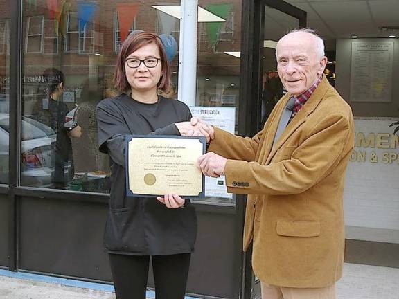 Supervisor Doug Bloomfield hands salon owner Dawn Zleng a certificate of recognition thanking her for creating her business in Goshen, wishing her the best, and looking forward to many years of success.