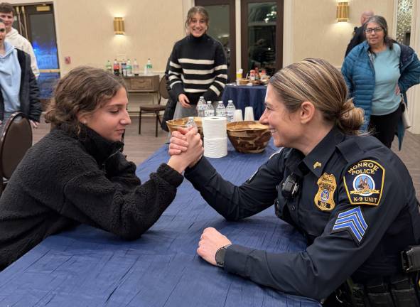 CTeen leader Lizzie Deskin of Monroe arm wrestles a police officer.