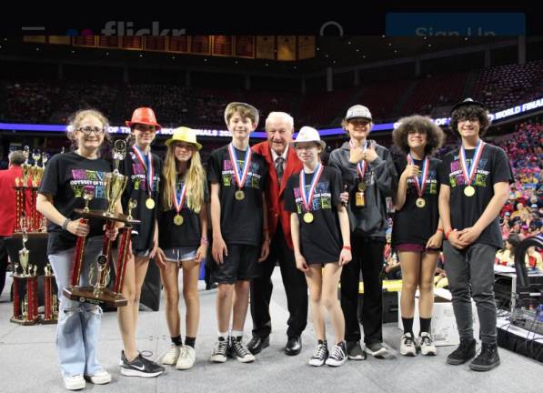 2022 Odyssey of the Mind World Champions, left to right: Coach Heidi Seligman, Olivia Marku, Grace McAndrews, Ethan Tetzlaff, Carly Seligman, Sion Siljkovic, Madison Hunter, and Nathan Hulse.