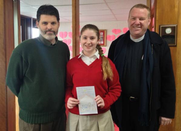Emily Davis, an eighth-grade student at St. John Catholic School in Goshen, was the winner of CYO Orange County&#x2019;s inaugural Christmas card art contest. She received her prize from Adam Kless (left), CYO Orange County Coordinator, and Father George Hafemann (right), St. John the Evangelist Church. Emily&#x2019;s artwork will be featured on Catholic Charities 2018 Christmas card. (Photo provided)