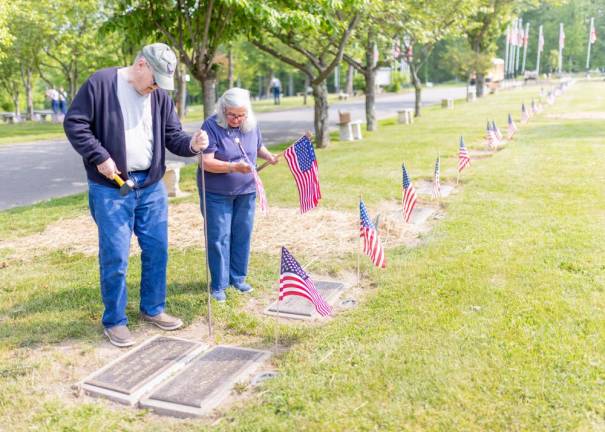 Bob &amp; Vivian Allen of Chester, parents of local solider First Lt. Louis E. Allen, places flags along the grave sites in Veterans Memorial Cemetery in Goshen, NY. Photo by Sammie Finch