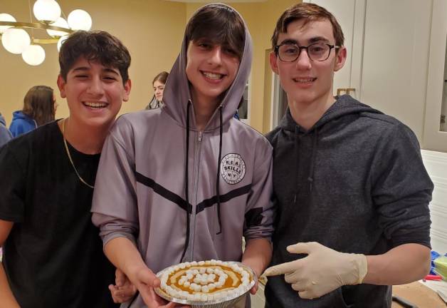 Eitan Einav of Monroe, Jamie Reich of Highland Mills and Ariel Koyfman of Chester bake and decorate a pumpkin pie for Thanksgiving for seniors at the CTeen Thanksgiving cook-off.