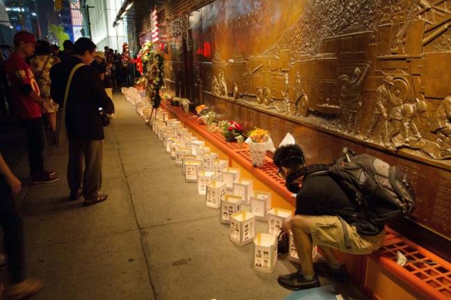 People pay their respects on the 13th anniversary of 911 outside FDNY Ten House located across the street from the World Trade Center. Ladder and Engine Co. 10 lost five members on that day. Photo by Robert G. Breese.