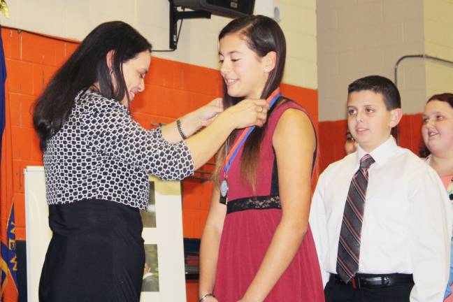 Alyssa Hernandez receives her medal from the Honorable Maria Vazquez-Doles while Michael Aglione and Kristina Norvell look on.