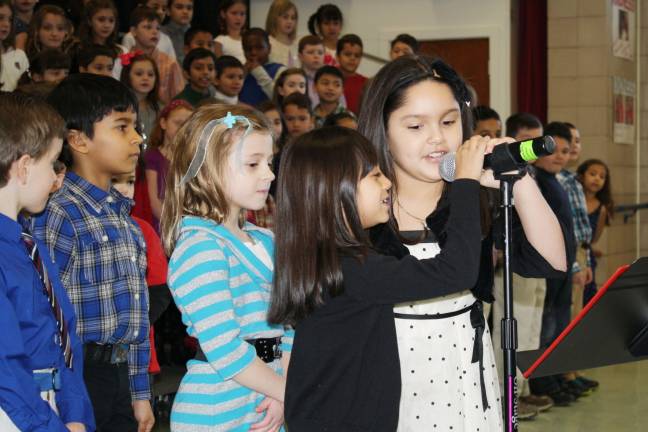 Zueleyka Martines and Yoelis De La Cruz speak into the microphone while classmates Carlos Alicia and Corinne Losgar look on.