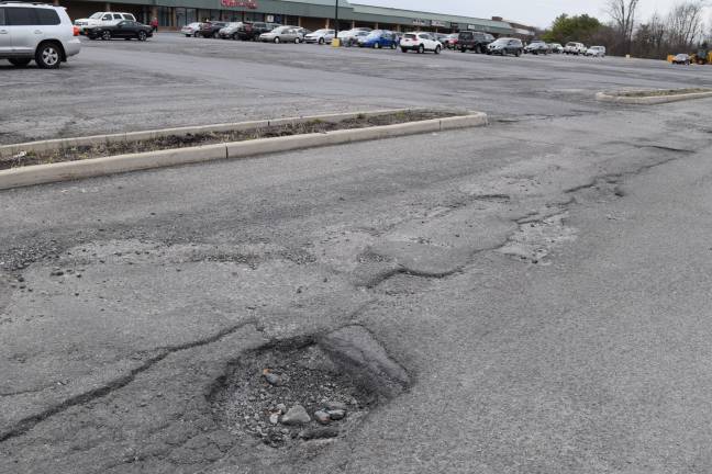 Photos by Erika Norton The Goshen Plaza parking lot continues to be full of large potholes and crumbling asphalt.