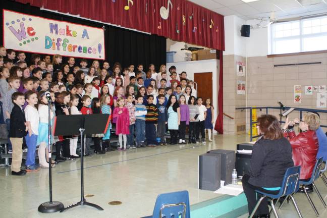 Music Teacher Betty Olivo leads the students in song.