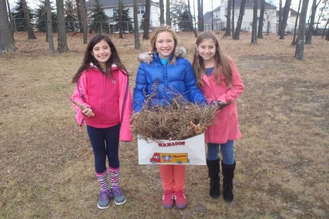 Julianna McGovern, Lauren Lingerman, and Madison Albanese get ready to mulch dead marigold stems in the fall.