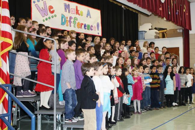 The students sing the Pledge of Allegiance.