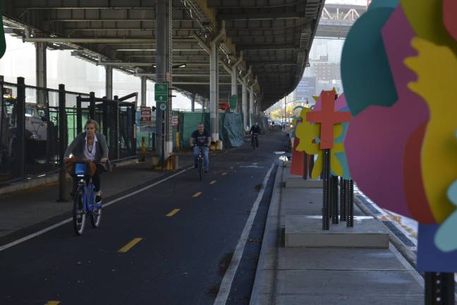 A six-foot median separating a two-way bike lane on South Street is bedecked by abstract, colorful figures. Photo: Diamond Naga Siu