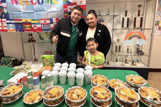 A student and her family pose with their display of food.