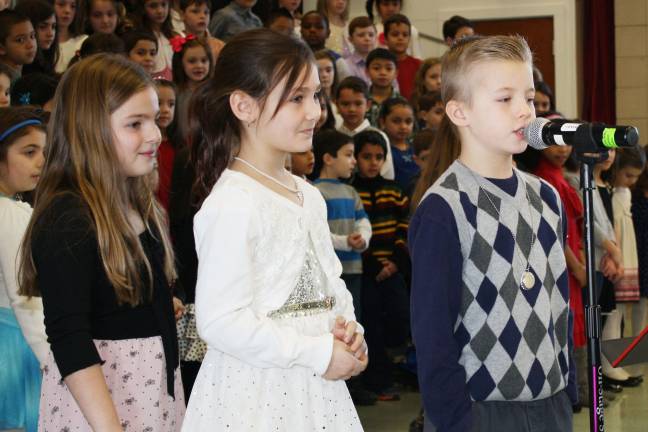 Clarissa Losgar and Charlize Dupper wait while Chase Singer speaks to the second grade families.