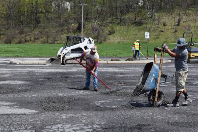 Photo by Erika Norton Workers from Orange County Paving could be seen working on the Goshen Plaza parking lot Friday.