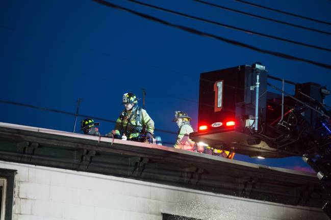 Goshen, NY Jan 13 2018. Firefighters on the roof of multi-dwelling aparment block.