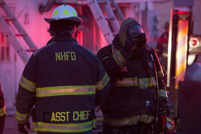 Goshen, NY Jan 13 2018. Firefighter in breathing apparatus returns from the inside of the burnt building