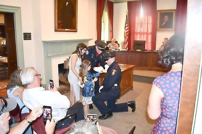 Newly promoted Sgt David Yates has his Sergeant badge pinned on by his daughter, Julie, as his girlfriend, Kaylee Konrad and Chief Watt look on.