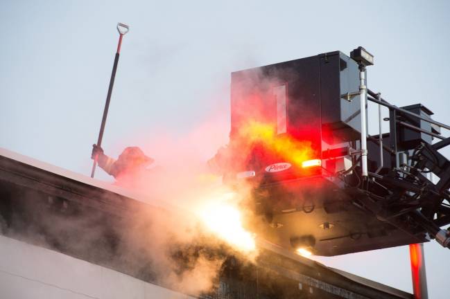 Goshen, NY Jan 13 2018. Firefighters on the roof of multi-dwelling aparment block.