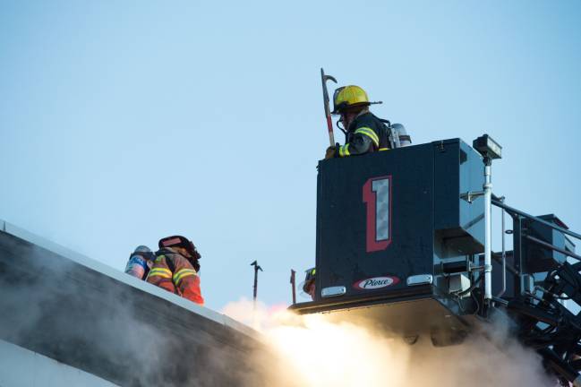 Goshen, NY Jan 13 2018. Firefighters on the roof of multi-dwelling aparment block.