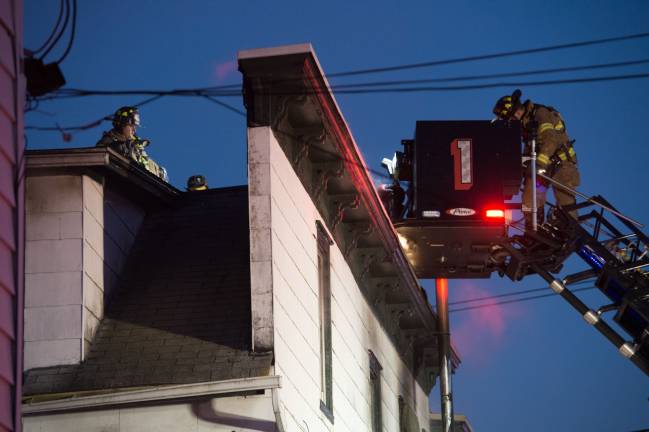 Goshen, NY Jan 13 2018. Firefighters on the roof of multi-dwelling aparment block.