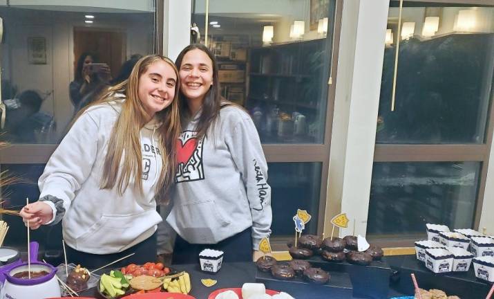 Sami Hamel and Haley Resty, of Monroe, enjoy a chocolate-themed buffet at CTeen’s “Chocolates for Cops” at the Chabad Center in Chester.