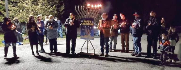 Lighting the Menorah at Chabad’s Hanukkah Drive-in Experience in Chester were “people who are pillars of light during the darkness of the pandemic:” Dr. Jen Reich of Highland Mills, Chana Burston, CTeen leader Amir Mosker of Monroe; nurse Serach Callan of Goshen, Rabbi Pesach Burston, Chabad Cares coordinator Dr. Ira Kanis of Monroe, school teacher Alan Friedman of Pine Bush, County Executive Steve Neuhaus, Police Officer Michael Cohn of Warwick and paramedic/first responders Lee and Michelle Sentell of Monroe. Photos courtesy of Chabad of Orange County/Rabbi Pesach and Chana Burston.